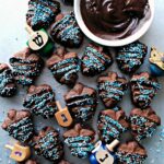 Chocolate Espresso Spritz cookies pressed in dreidle shapes, sandwiched with melted chocolate and decorated with nonpareils.