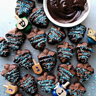 Chocolate Espresso Spritz cookies pressed in dreidle shapes, sandwiched with melted chocolate and decorated with nonpareils.