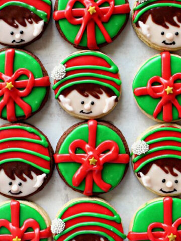 Sugar cookies decorated like elf on the shelf and gifts.