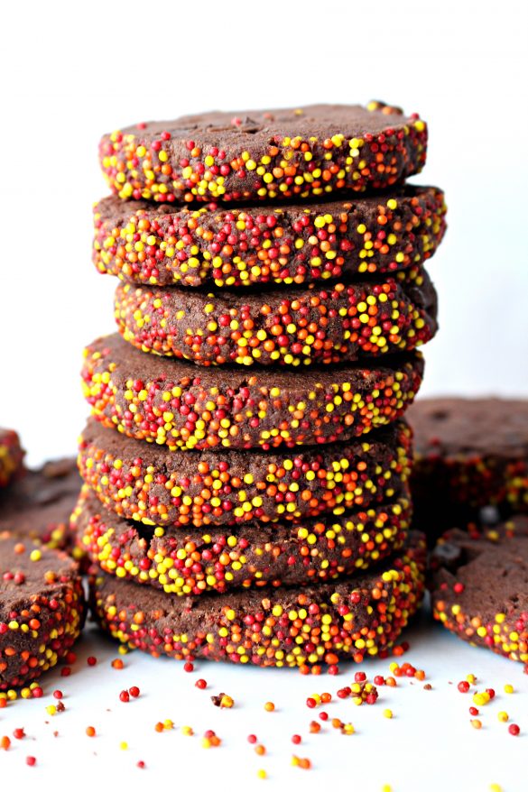Spiced Chocolate Shortbread Cookies in a stack showing the red, orange, and yellow sprinkles on the edges of each cookie.