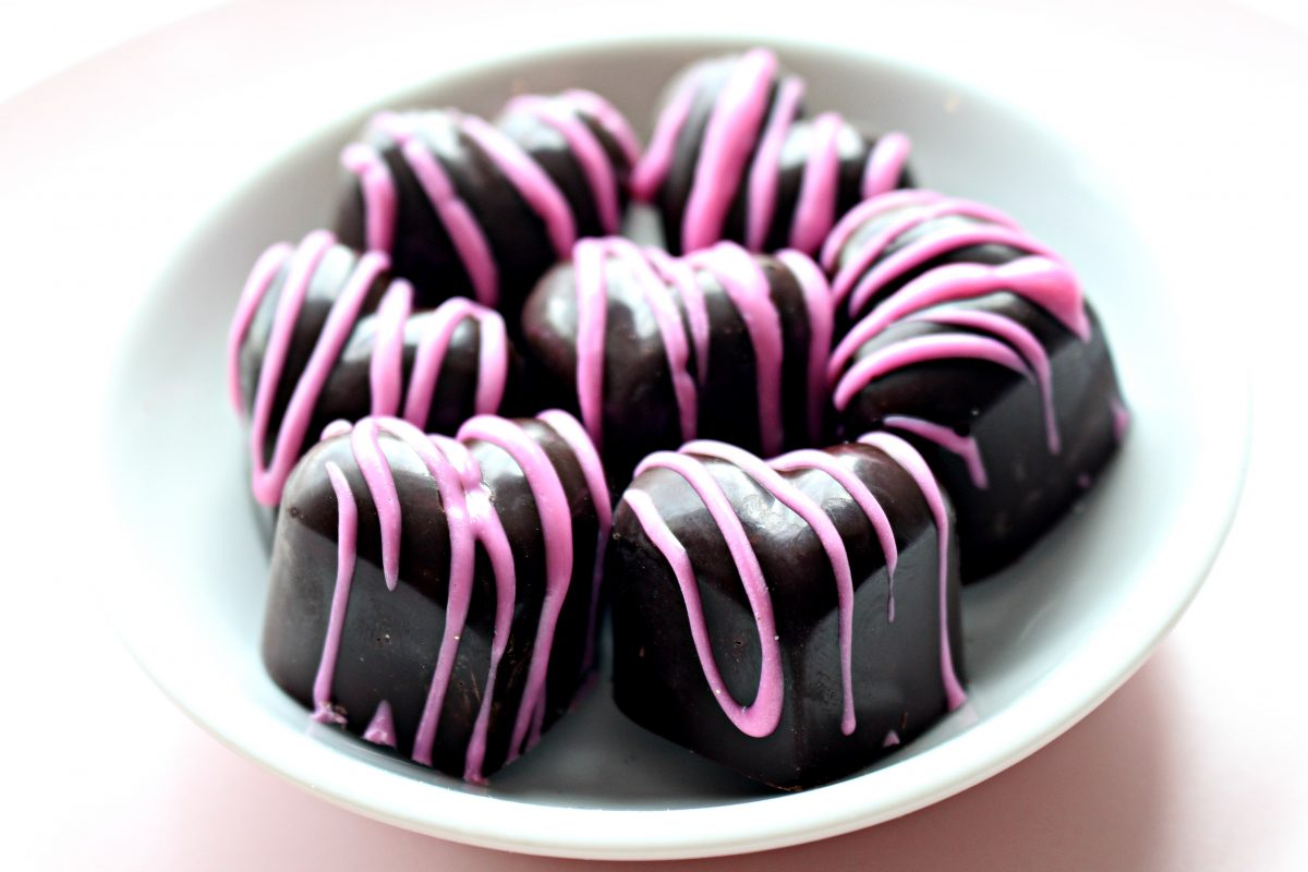 Dark Chocolate Marshmallow Hearts with pink stripes on a small round white plate.