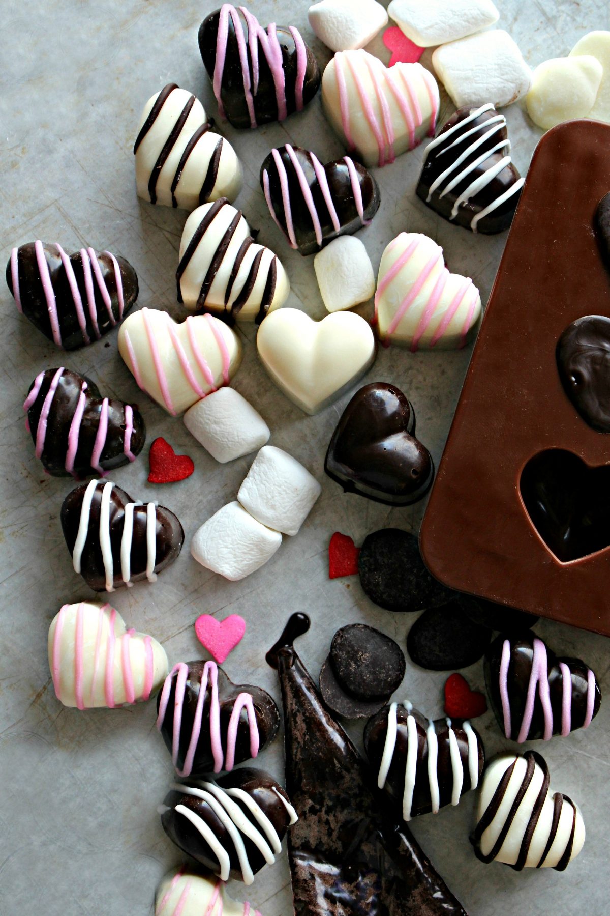 Chocolate molded hearts in dark chocolate and white chocolate decorated with contrasting stripes. 