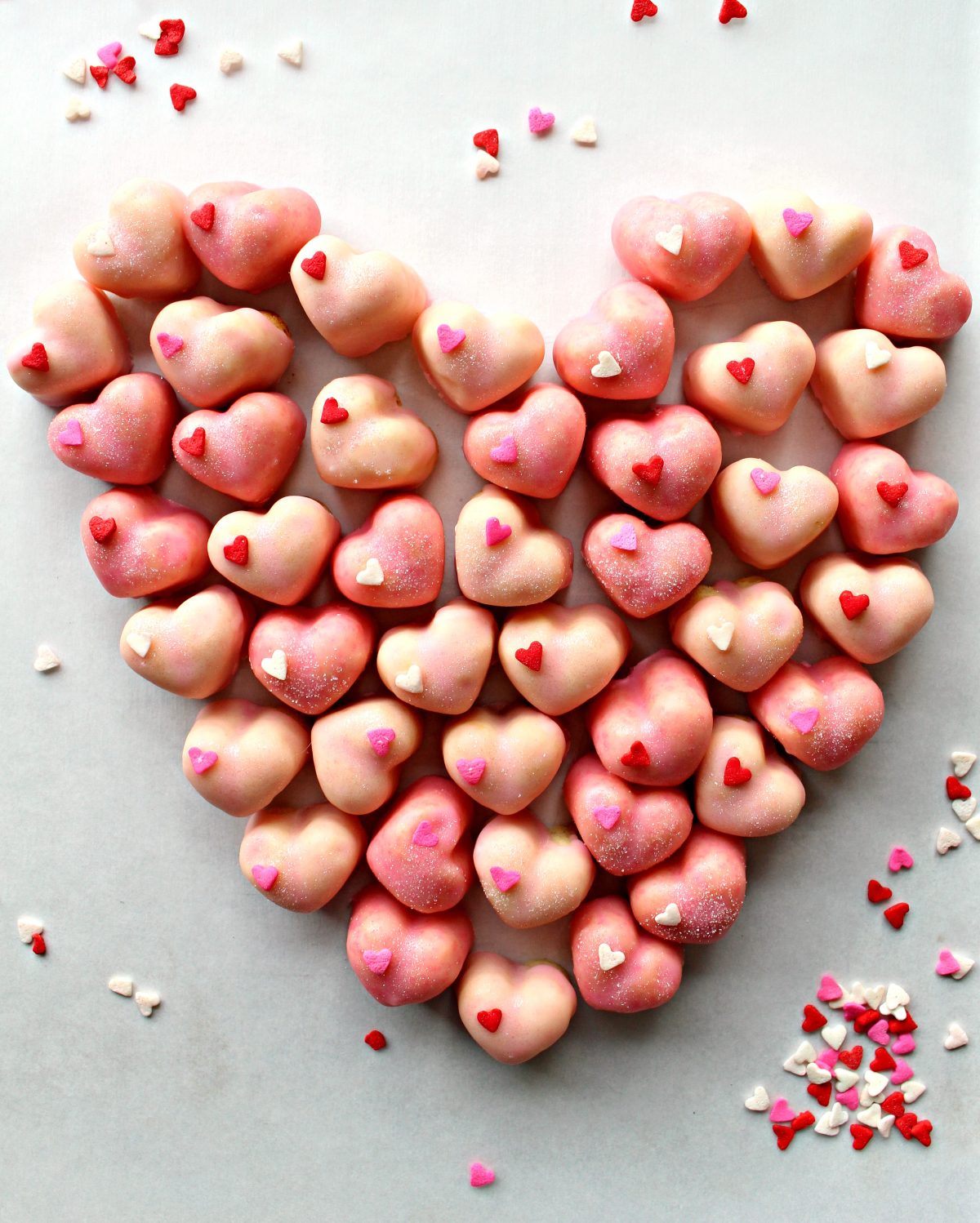 Sugar Cookie Hearts iced pink, each with one heart sprinkle, grouped in a heart shape.