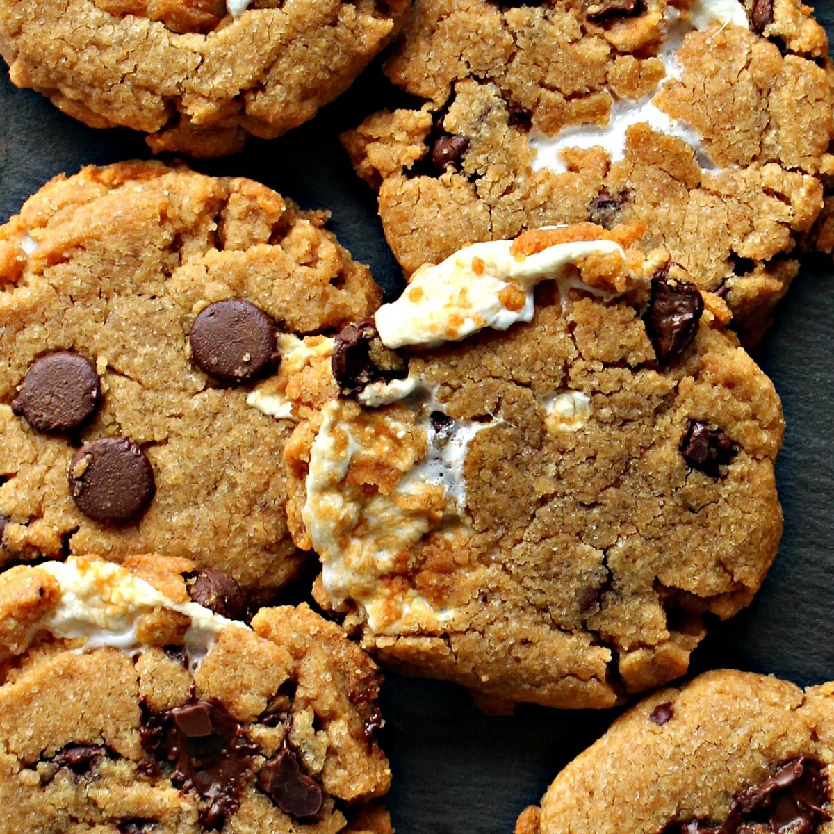  Closeup of s'mores cookies showing peanut butter dough, chocolate chips, and melted marshmallow.