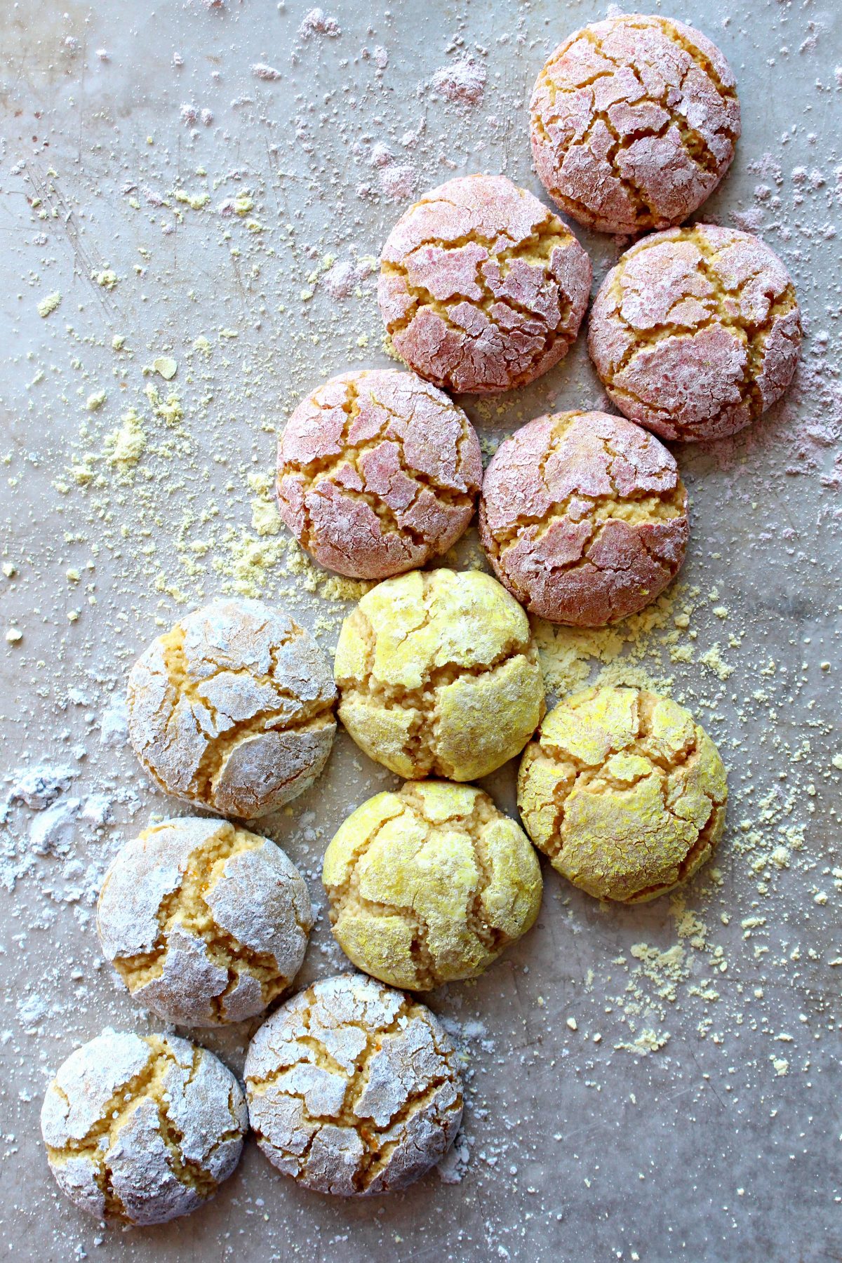 Crackled topped almond cookies coated in pastel colored powdered sugar.