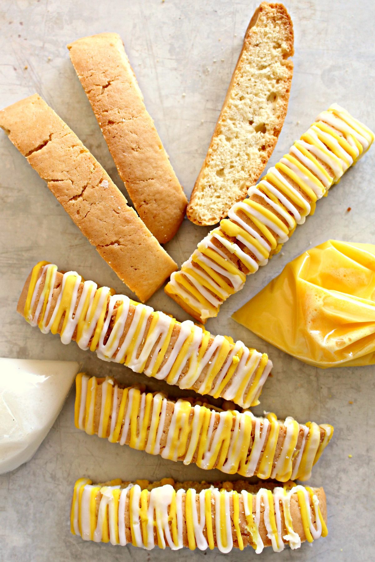 Lemon Biscotti, some decorated with yellow and white icing zigzags on top.