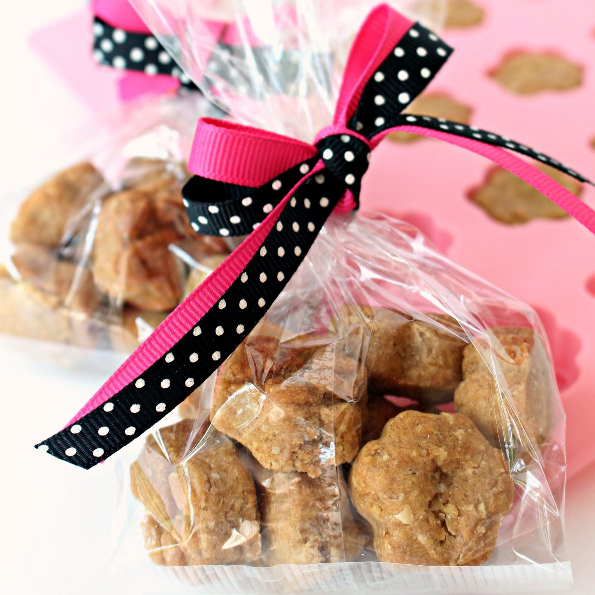 Paw Prints Dog Cookies wrapped in a clear cellophane bag with pink and black ribbon.