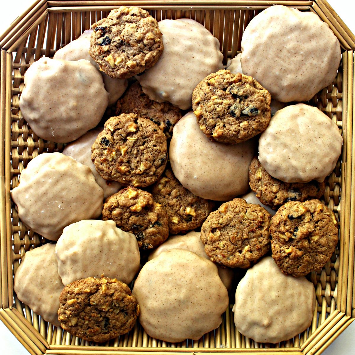 Apple Raisin Oatmeal Cookies, iced and plain, in a shallow, square basket.
