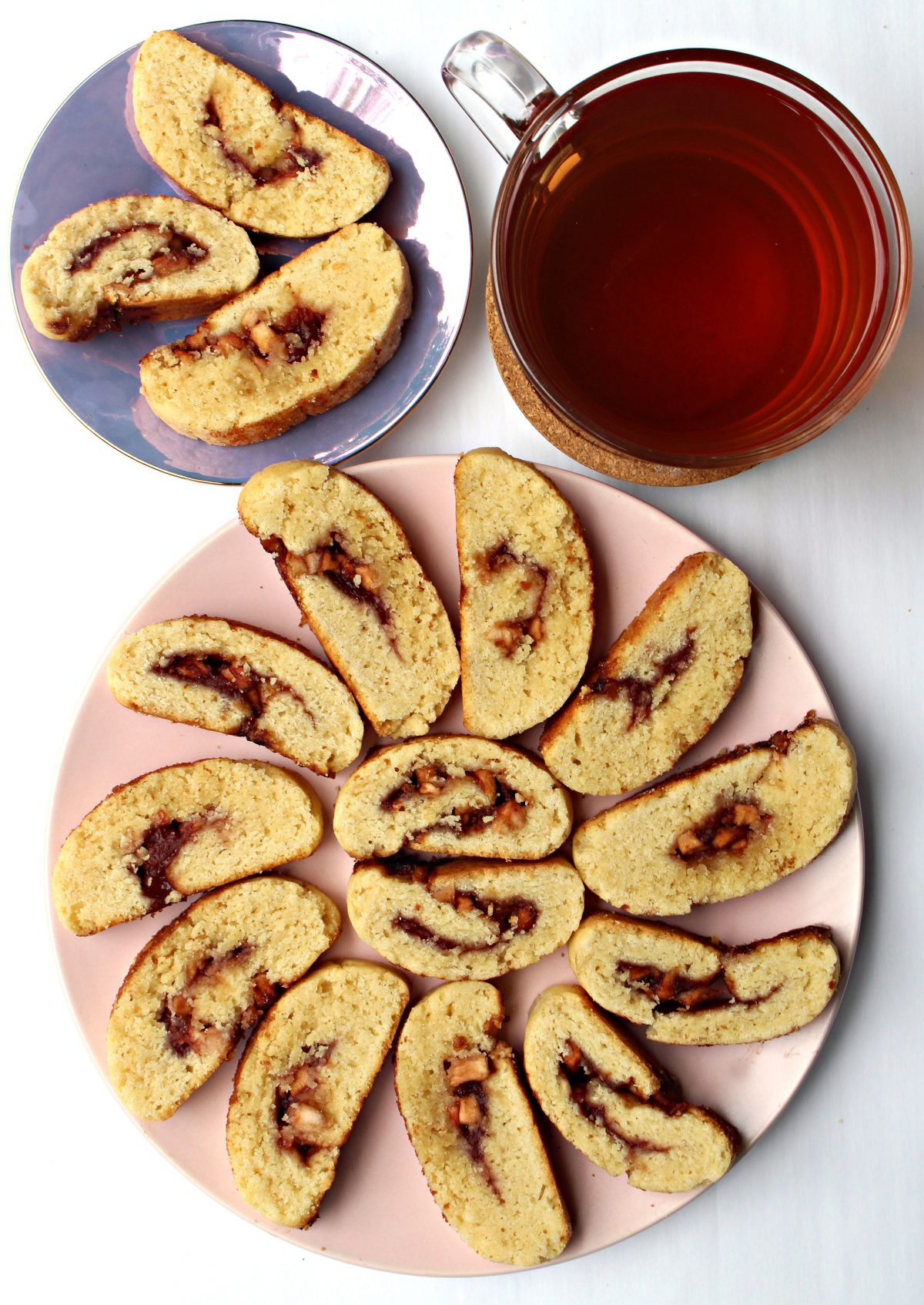 Plates with cookie slices made from dough logs with cherry jam centers.