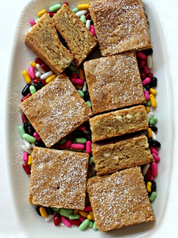 7 Root Beer Float Bars on a white platter with colorful licorice candies
