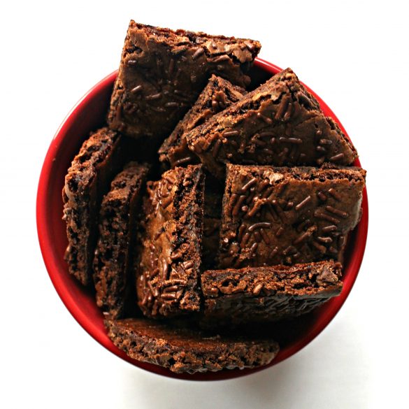 Squares of brownie brittle in a red bowl
