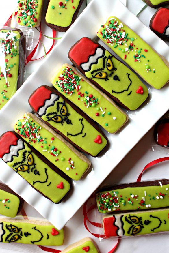 Decorated Grinch Cookie sticks and green sprinkled cookie sticks on a white platter