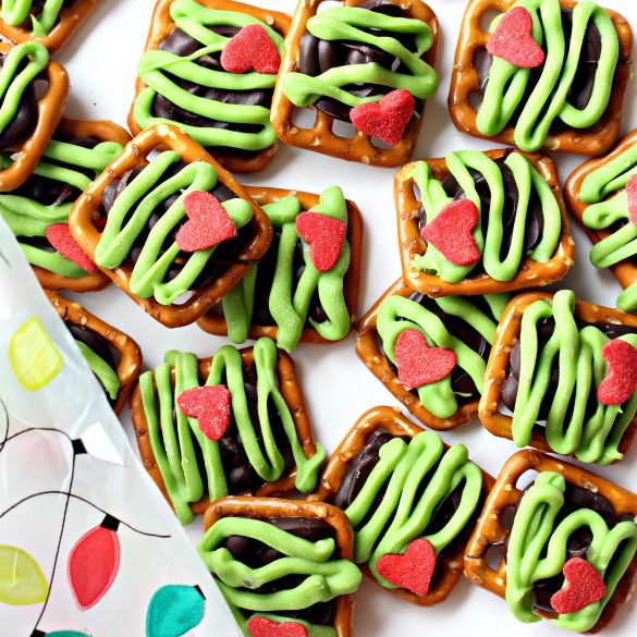 Grinch Pretzels topped with chocolate, green zigzags and a red heart.