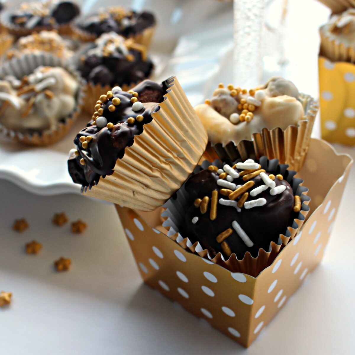 Two No Bake Chocolate Peanut Butter Cookies in a gold and white polka dot candy cup.