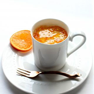 Orange Mug Cake in white mug on plate