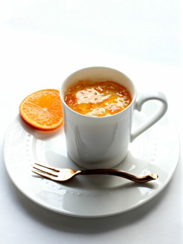 Orange Mug Cake in white mug on plate