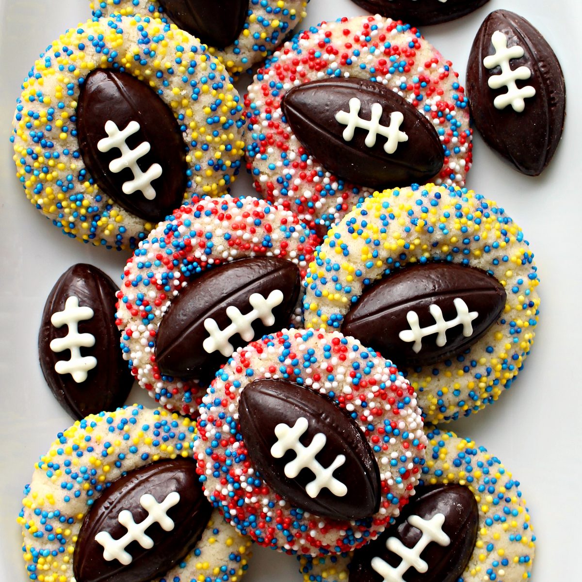 Shortbread Thumbprint Cookies with chocolate football centers and team colored sprinkles.