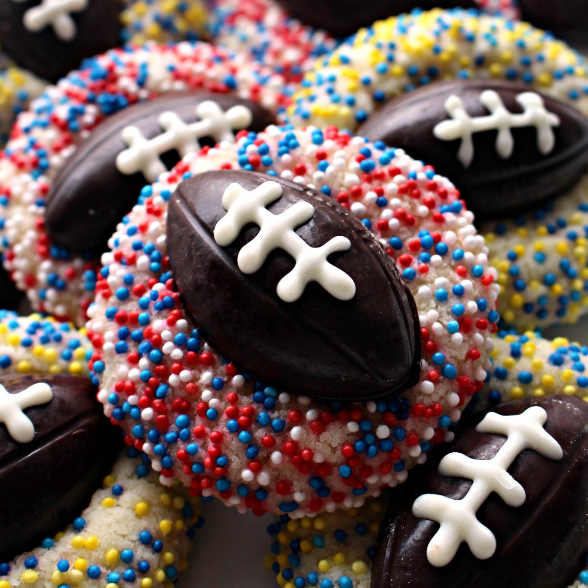 Closeup of a Shortbread Thumbprint cookie with chocolate football and red white and blue sprinkles.