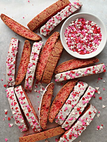 Cinnamon Red Hot Biscotti Cookies on a baking sheet with heart sprinkles