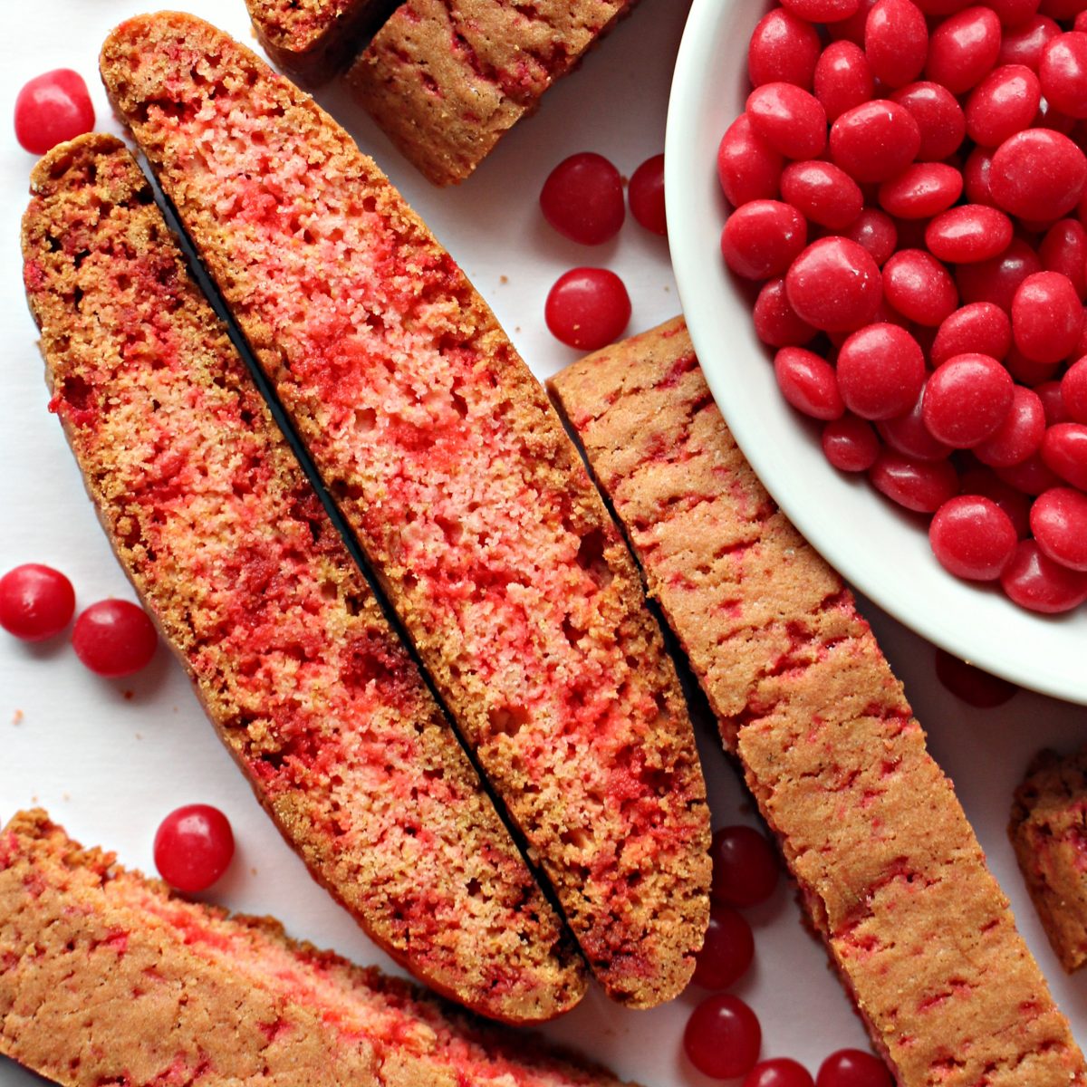 Pink and red biscotti with bowl of Red Hots.