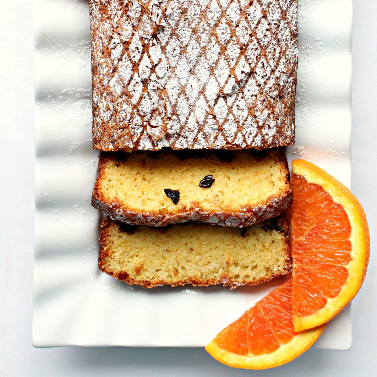 Closeup of sliced Orange Olive Oil Cake sliced on a platter.