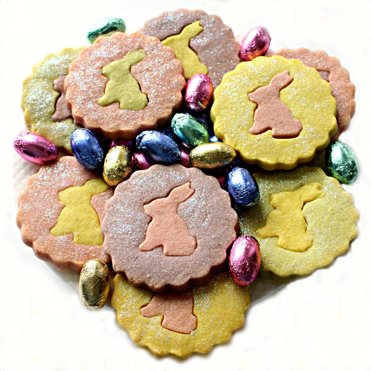 Pastel colored  shortbread cookies with contrasting bunny centers on a plate.