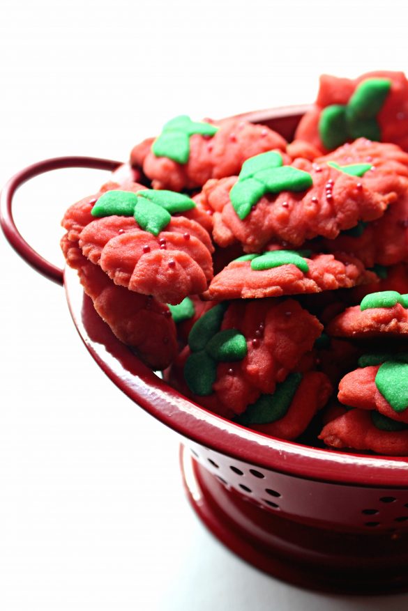 Side view of Strawberry Press Cookies in a red strainer bowl 