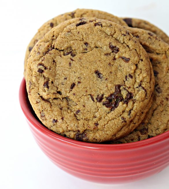 Closeup of a brown, chocolate speckled Chocolate Chip Molasses Cookie in a red bowl