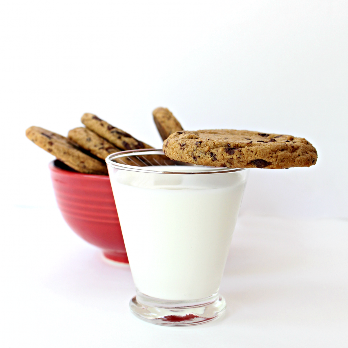 cookie balanced on rim of glass of milk