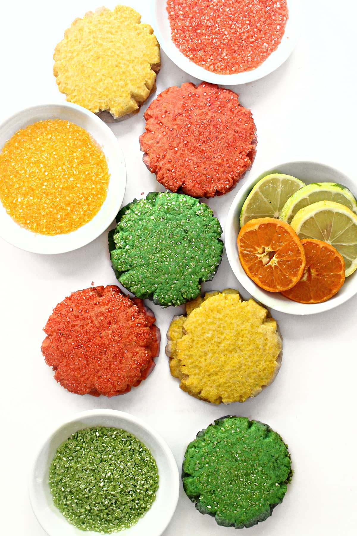 Yellow, orange, and green sugar cookies on white background.