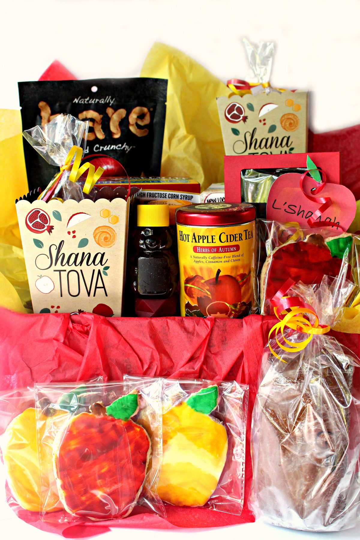 Rosh Hashanah gift care package box filled with homemade and purchased gifts with apples and honey flavors.