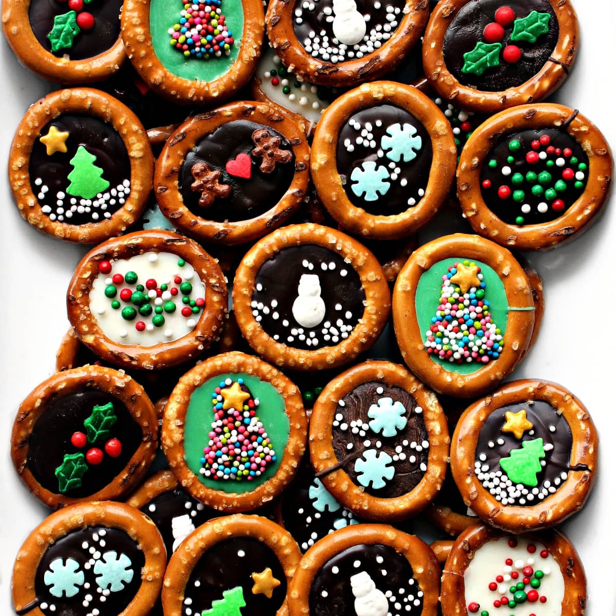 Closeup of decorated ring pretzels with many different designs made with sprinkles on chocolate.