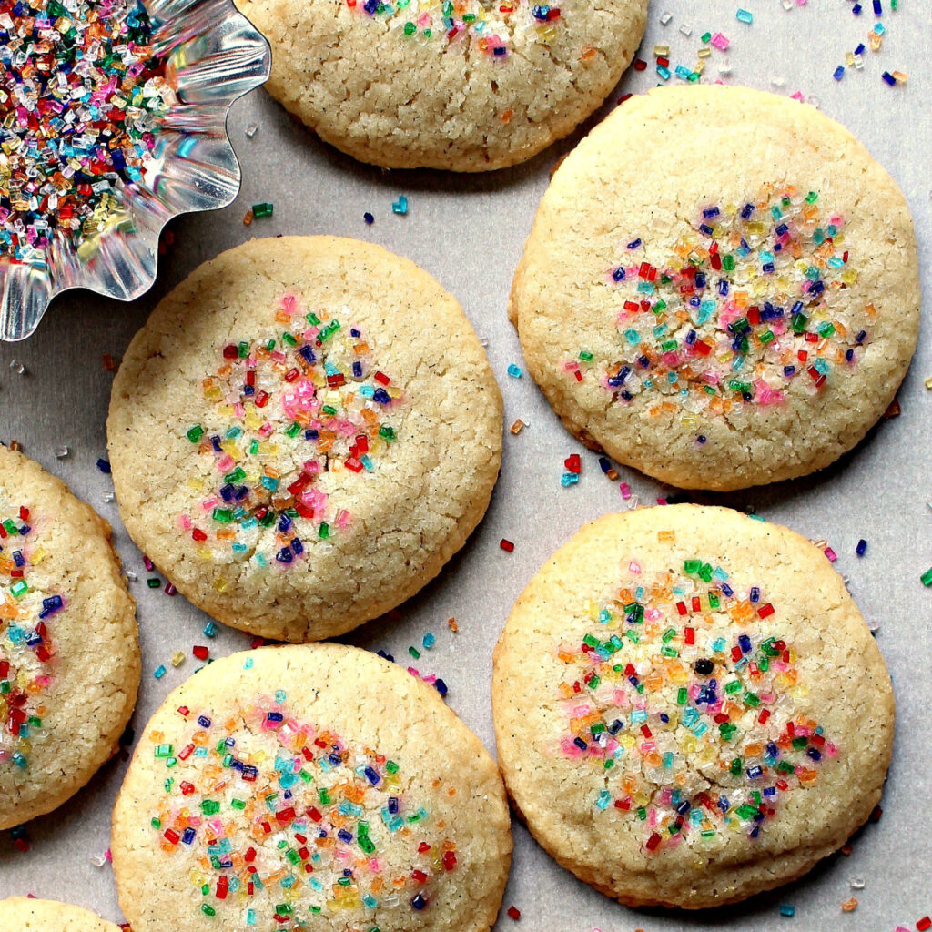 Round, flat Vanilla shortbread cookies with multicolored sugar sprinkles.