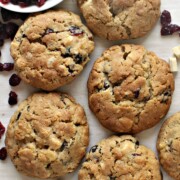 Cranberry White Chocolate Cookies, large and golden brown,  with chopped white chocolate and a bowl of cranberries