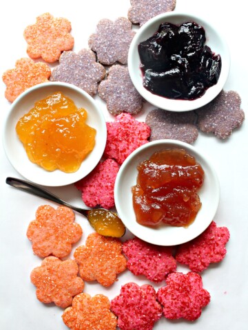Jam Butter cookies cut out in flower shapes, colored orange, pink, or purple.