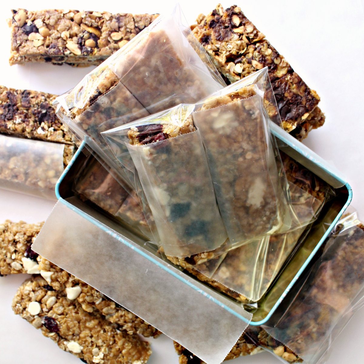 Granola bars, wrapped in wax paper then cellophane bags, packed for shipping in a cookie tin.