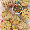 Funfetti Sugar Cookies, with rainbow sprinkles, a bowl of sprinkles and cookies wrapped in  clear cellophane bags.
