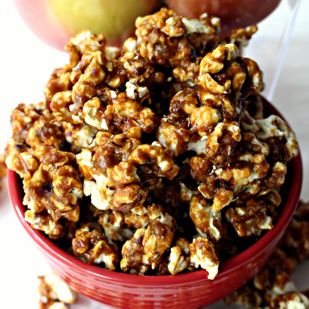 Close up of honey caramel coating on popcorn in a red bowl.