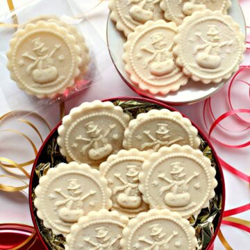 Flat discs of marzipan imprinted with a snowman cookie stamp.