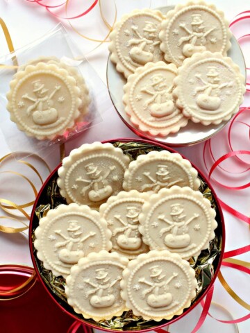 Flat discs of marzipan imprinted with a snowman cookie stamp.