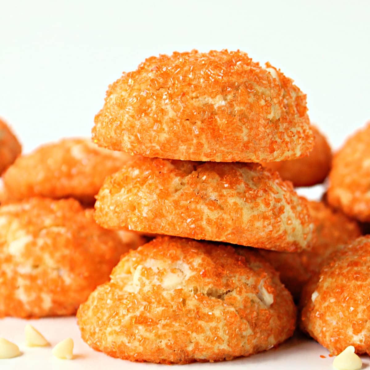 Stack of three puffy cookies coated in orange sugar.