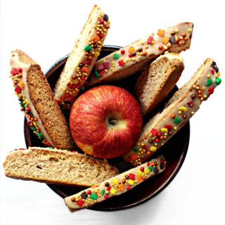 Apple biscotti in a bowl with an apple.