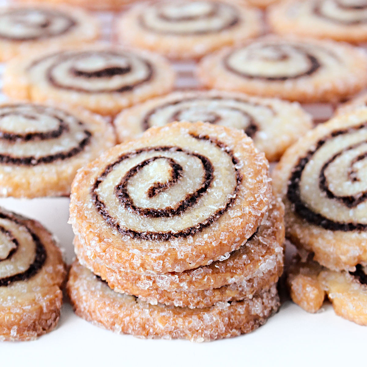 Closeup stack of rugelach cookies showing sugar coating and spiral of chocolate filling.