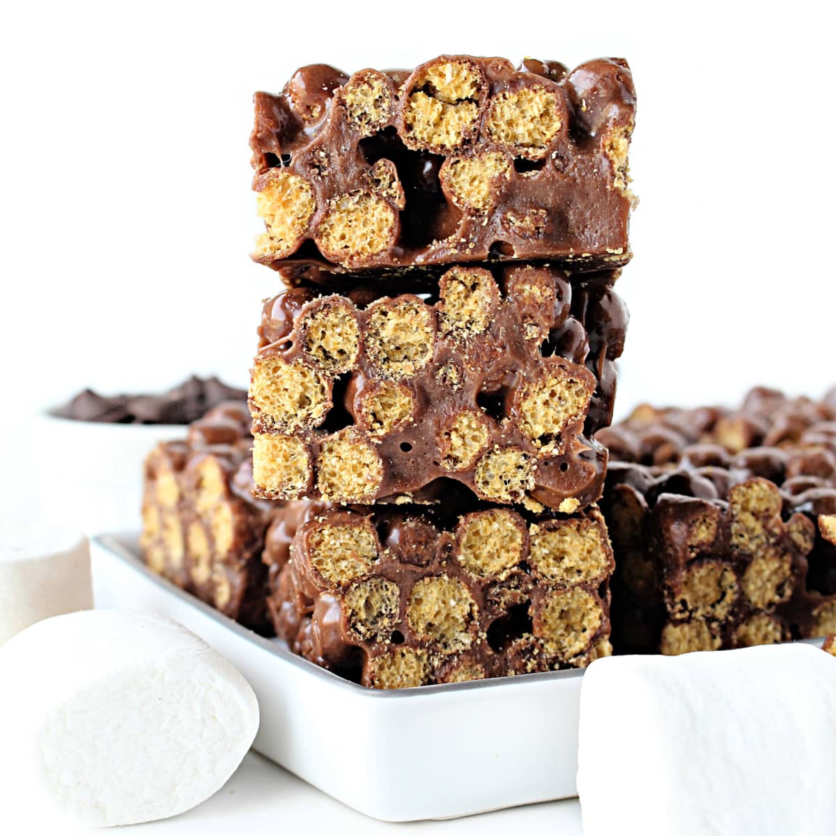 Close up stack of cereal bars showing cereal puffs connected by chocolate marshmallow mixture.