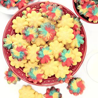 Spritz cookies, some plain and some colored, on a red plate.