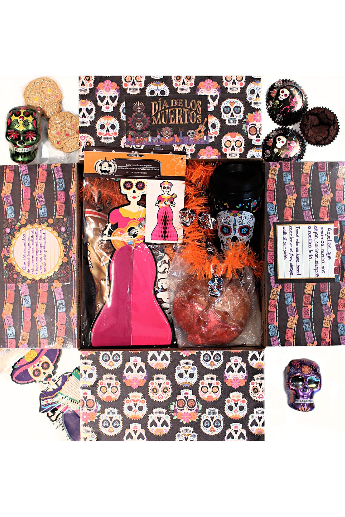 Dia de los Muertos care package with the box flaps decorated and filled with baked good and holiday decorations.