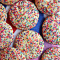 Sugar cookies covered with rainbow nonpareil sprinkles.