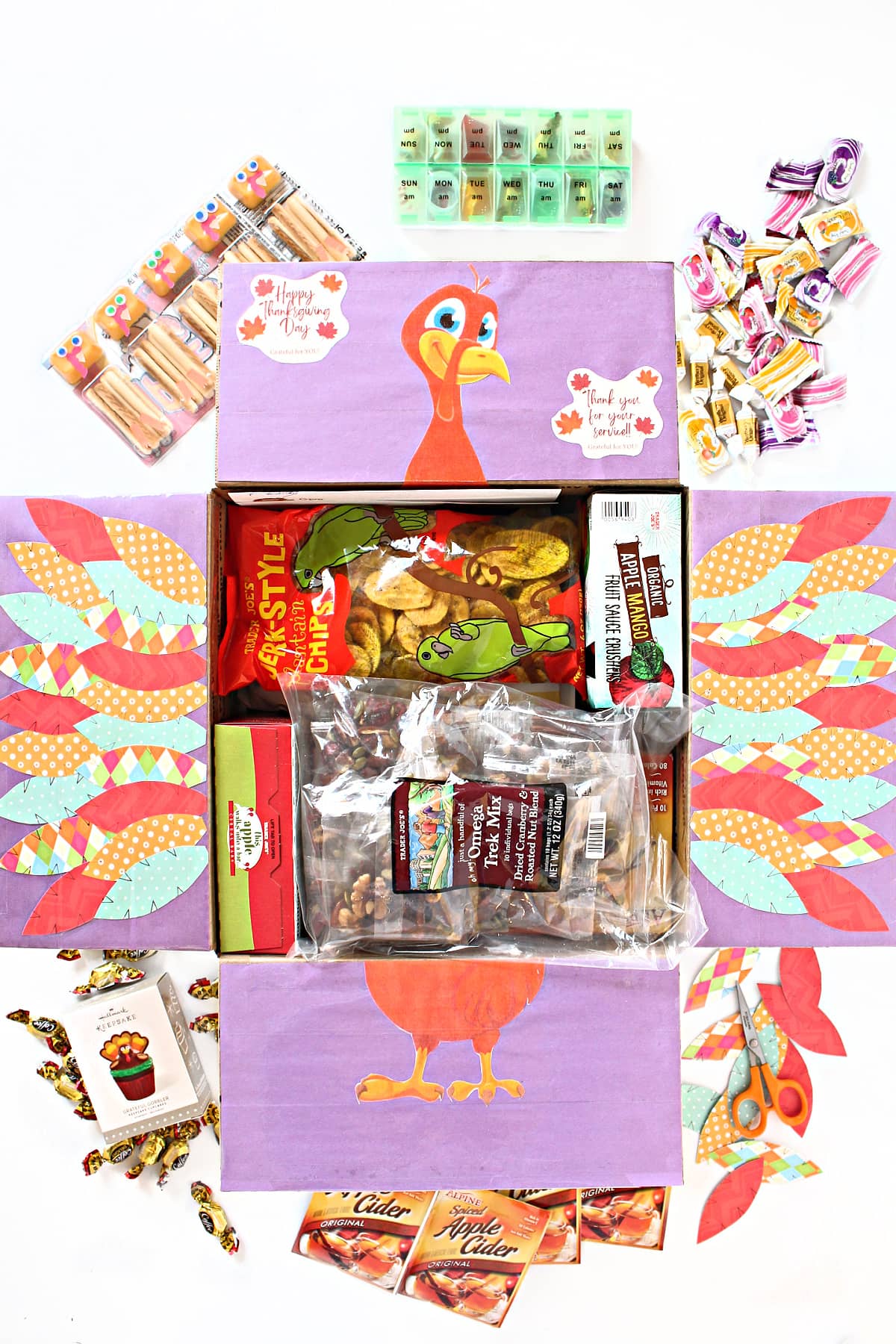 Thanksgiving Care Package filled with fall treats and box flaps decorated with a smiling turkey.