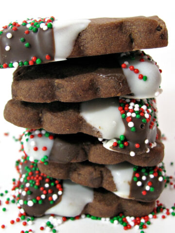 Stack of choclate shortbread cookies with dipped choclate and sprinkles.