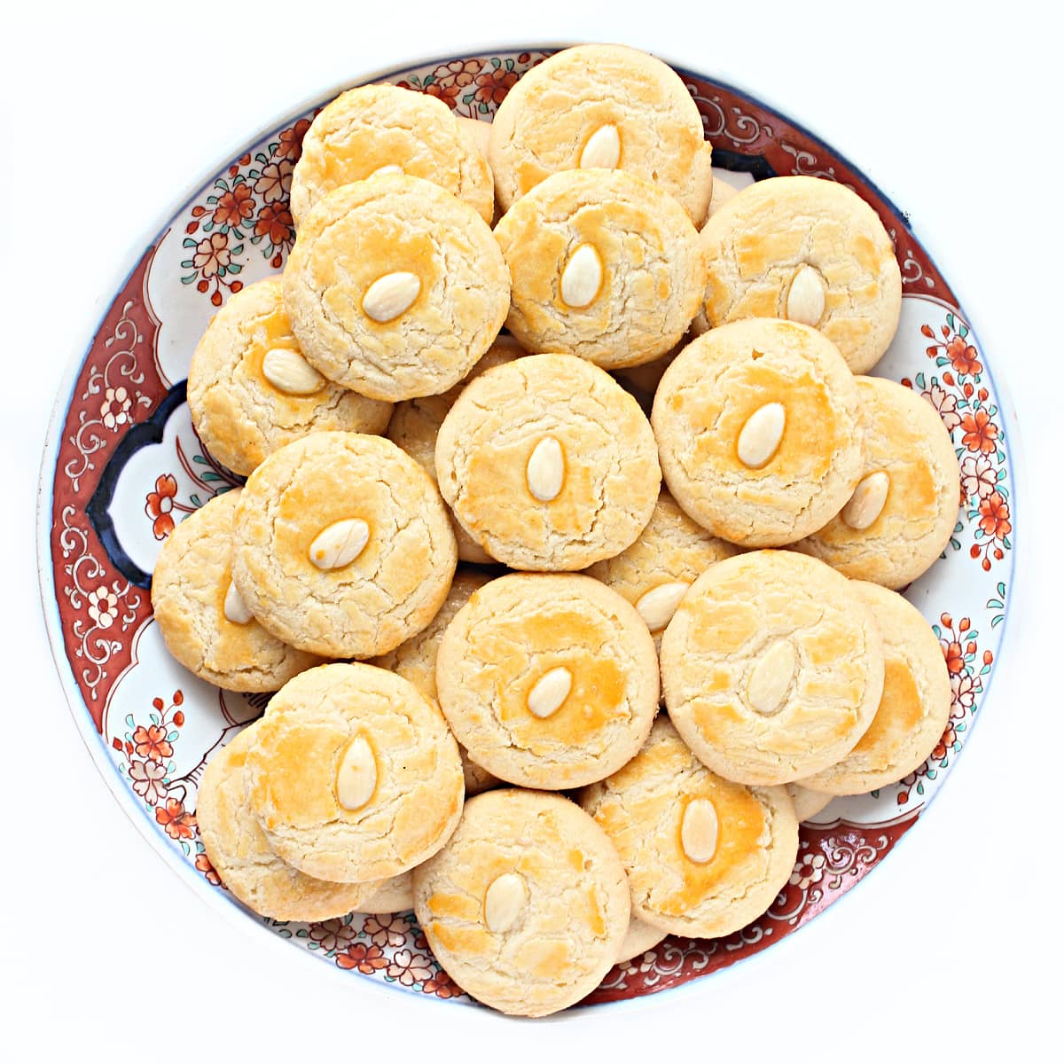 Large platter filled with cookies each topped with an almond.